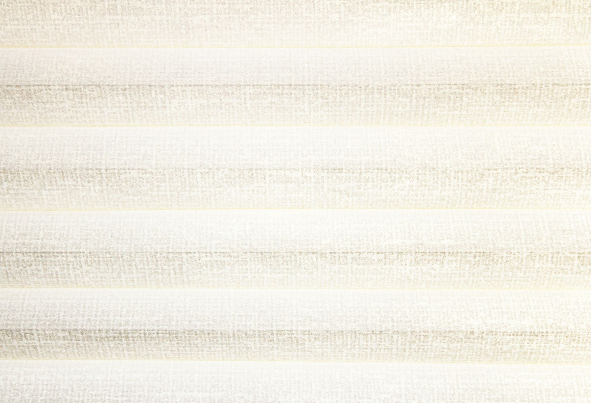 A close-up view of a cellular shade with alternating cream colors 
