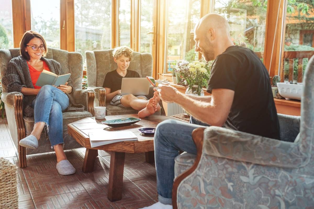 A family sitting in a sunroom with the shades raised to let in light near San Antonio, TX