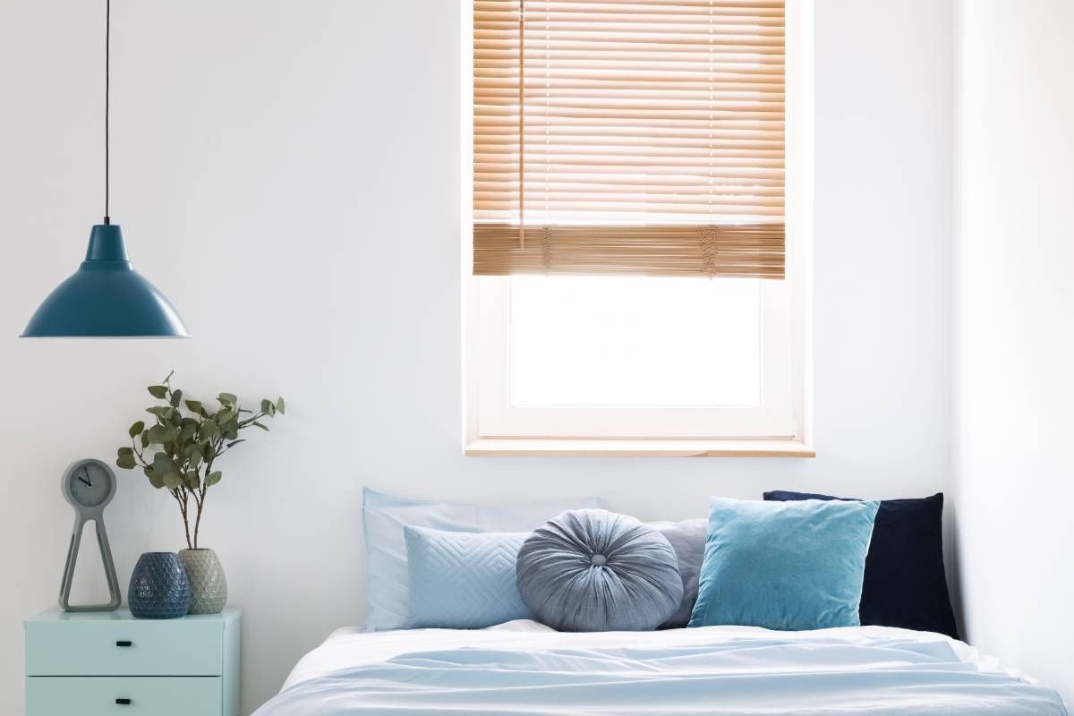 A bedroom with light blue decor and new window blinds at Blinded by Delight Window Coverings & Design near San Antonio and Boerne, Texas (TX)