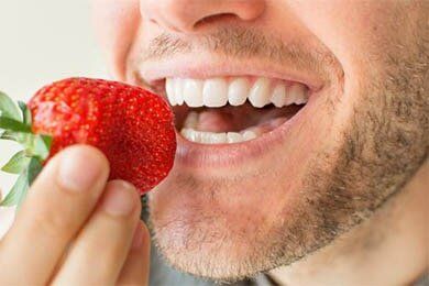 Man Eating Strawberries — Teeth Whitening in South Lawrence, MA