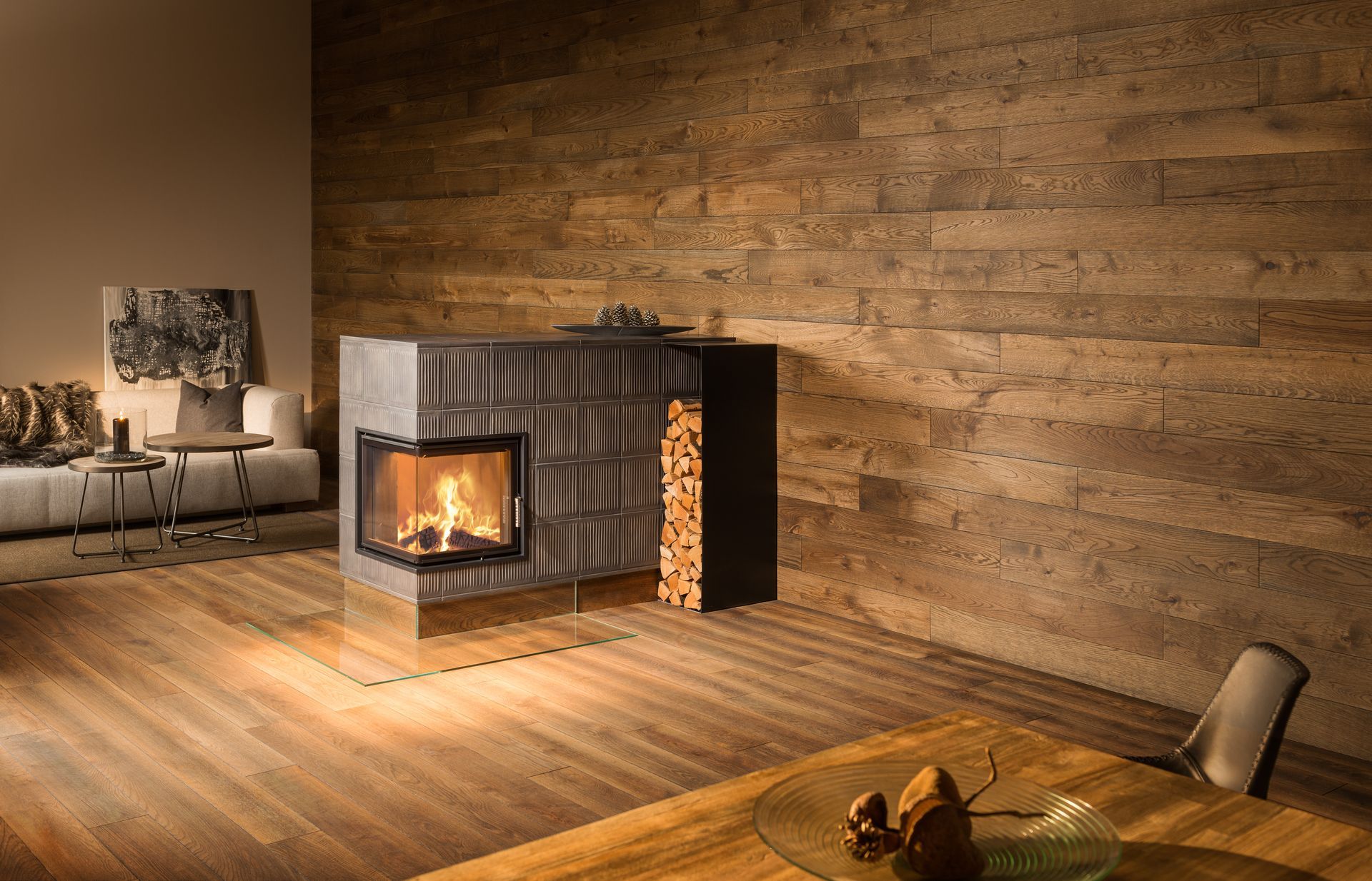 Moderner Kamin mit brennenden Flammen und Holzaufbewahrung in einem Raum mit Holzboden und strukturierter Wand.