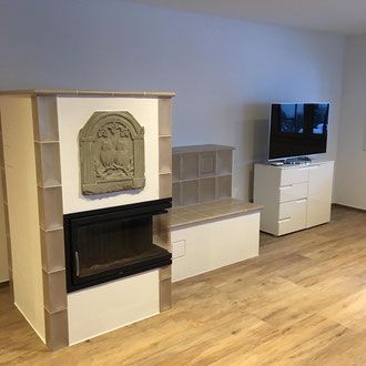 Helles Wohnzimmer mit weißen Möbeln, Zugang zur Terrasse und einem dekorativen Stuhl.