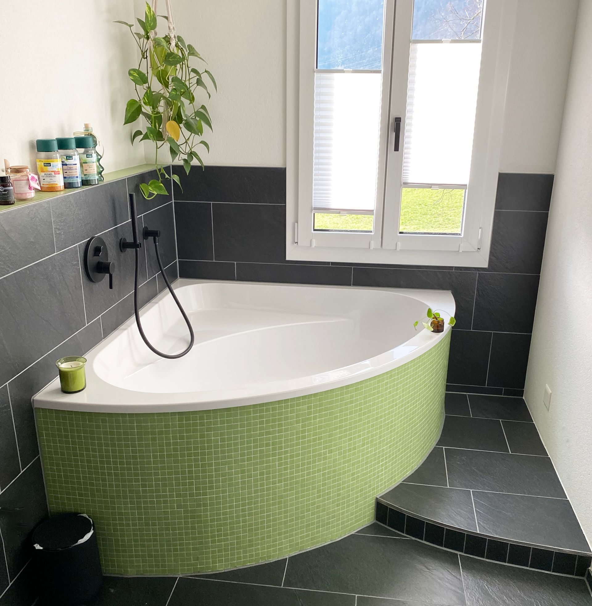 Modernes Wohnzimmer mit Kamin, grauem Fliesenboden und Blick ins Freie.