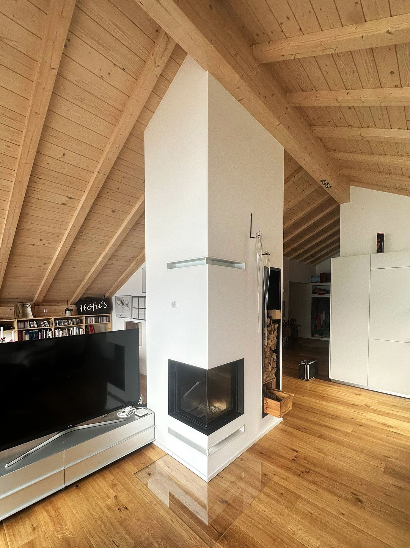 Modernes Wohnzimmer mit Kamin, grauem Fliesenboden und Glaswand zur Terrasse.