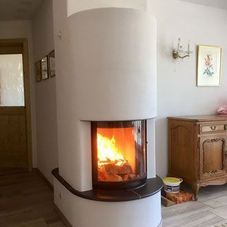 Dusche mit beigefarbenen Fliesen, Duschkopf, Wasserhahn und eingelassenem Seifenspender.