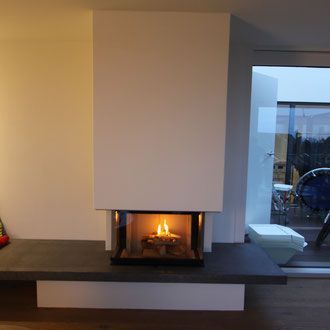 Eckbadewanne mit Mosaikfliesenverkleidung, Chromarmaturen und neutralfarbigen Fliesenwänden.