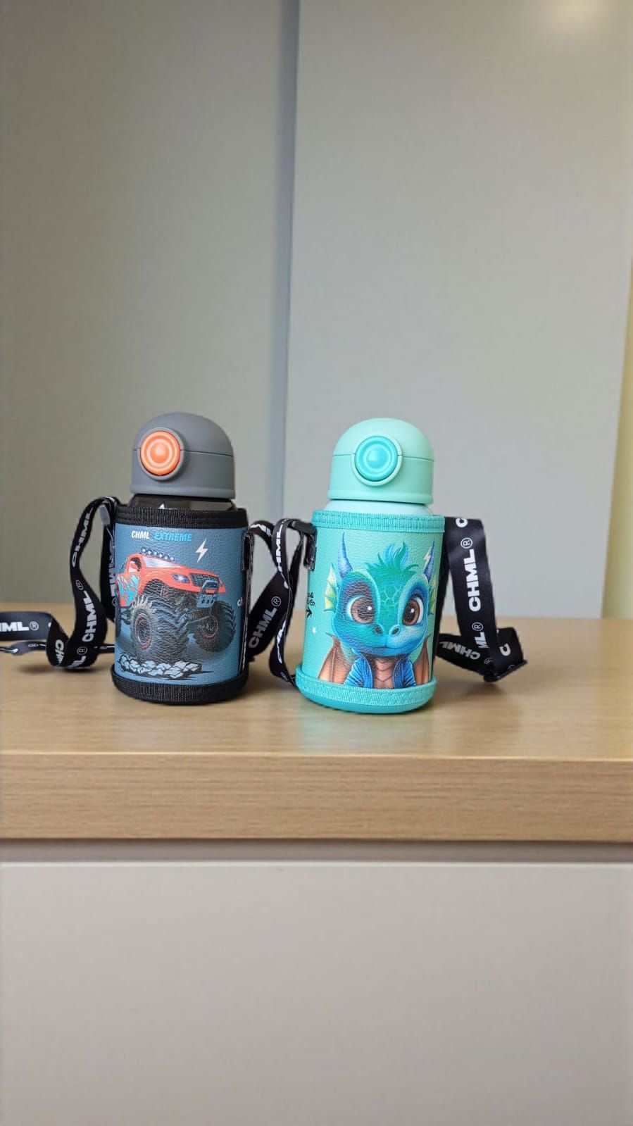 Tres coloridas botellas de agua con caras de animales y correas para transportarlas.