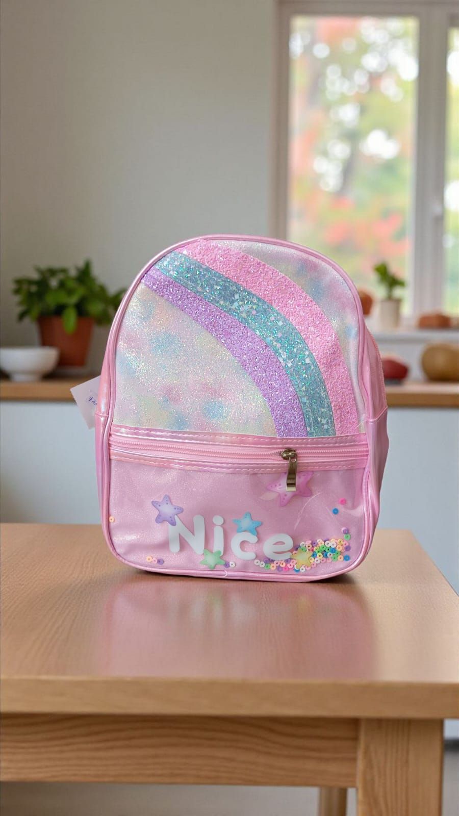 Dos mochilas pequeñas y coloridas. Una rosa y otra azul, con estampado de arcoíris y la palabra