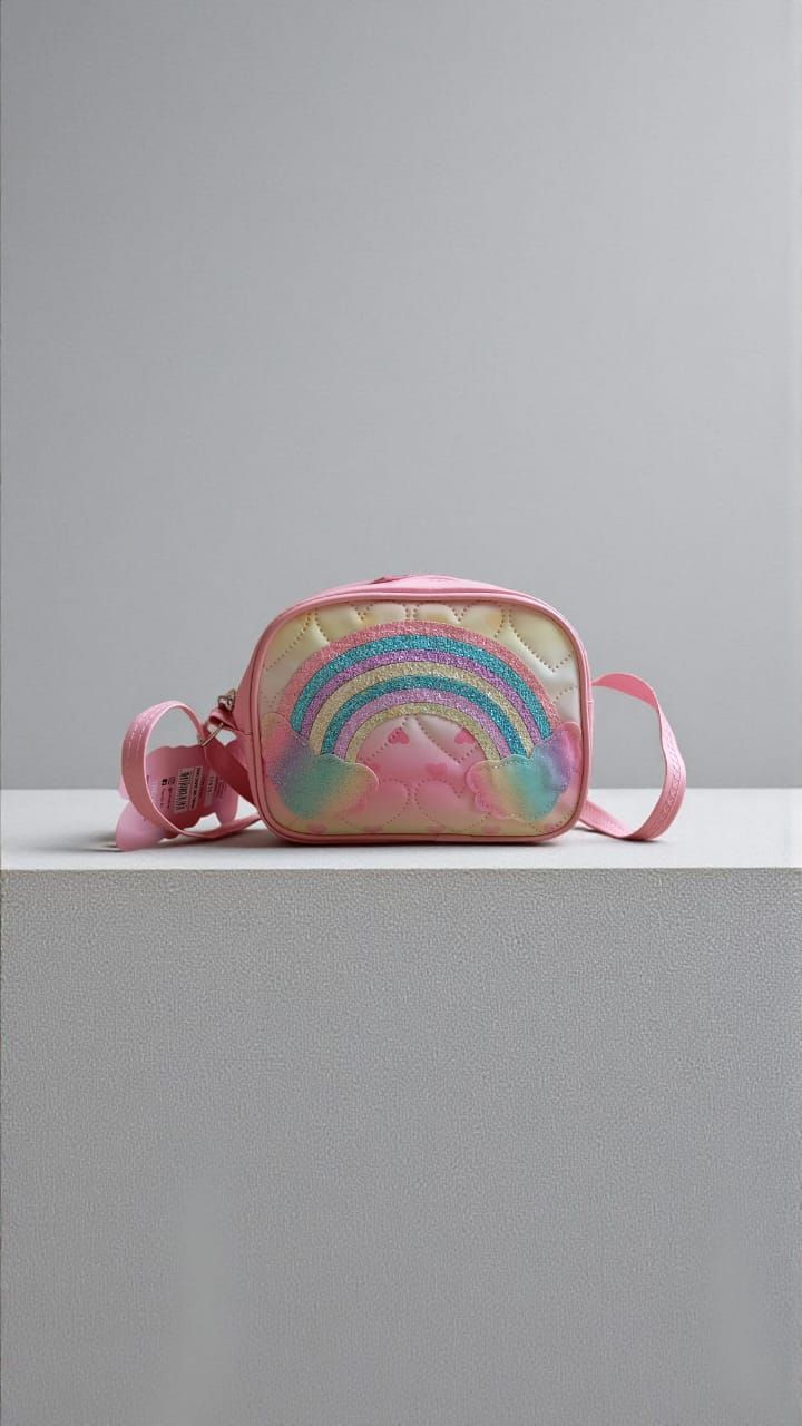 Monedero azul con diseño de arcoíris sobre una mesa de madera, con fondo desenfocado de una habitación y una ventana.