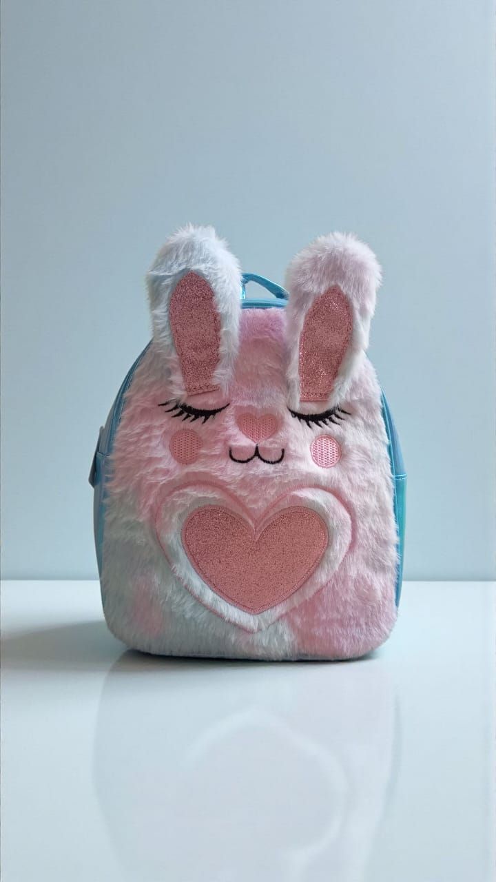 Mochila rosa de conejito con ojos cerrados y un corazón.
