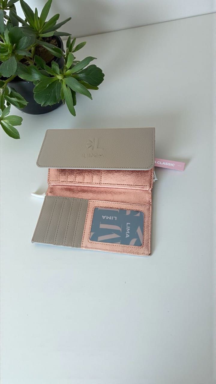 Cartera de piel color canela con cierre de solapa y tachuelas, sobre fondo gris.