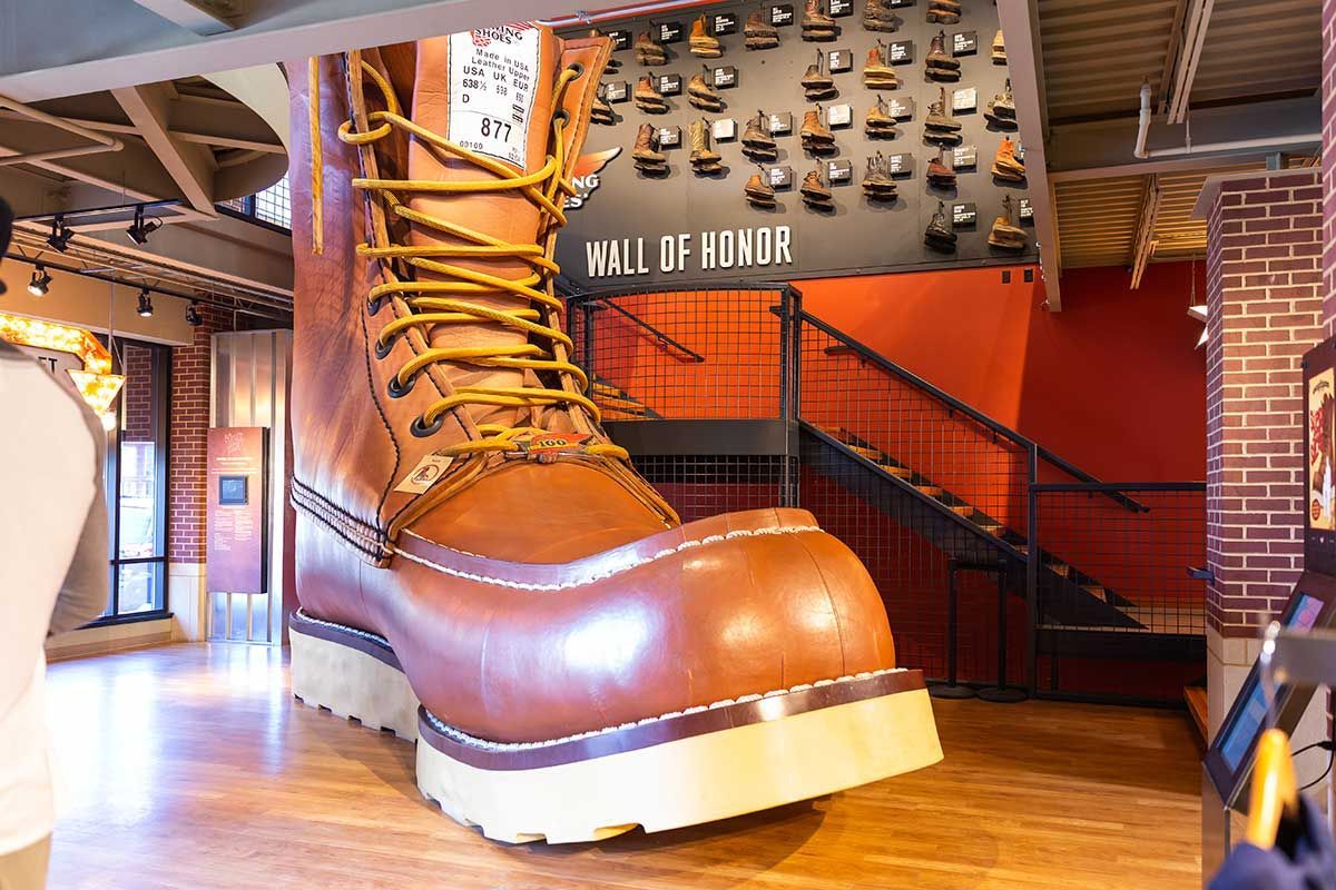 A giant boot is sitting on a wooden floor in a room.