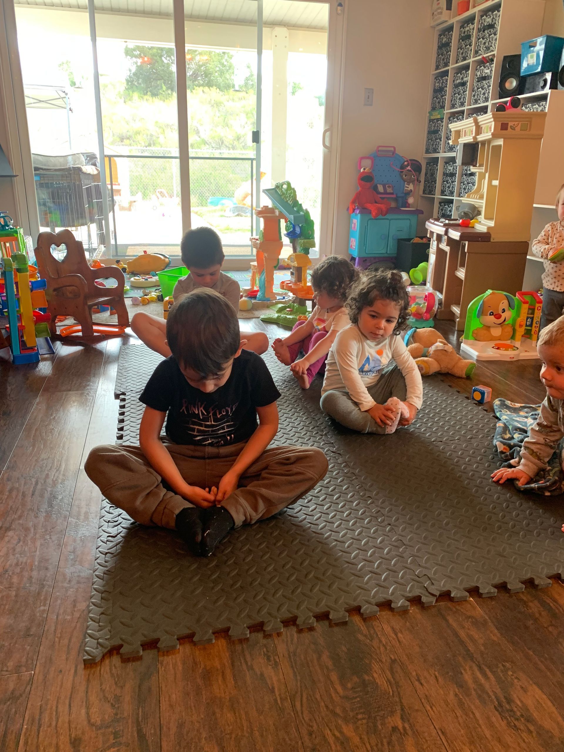 A group of children are sitting on the floor in a room.