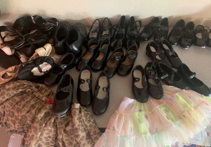 A bunch of shoes and skirts are sitting on a table.