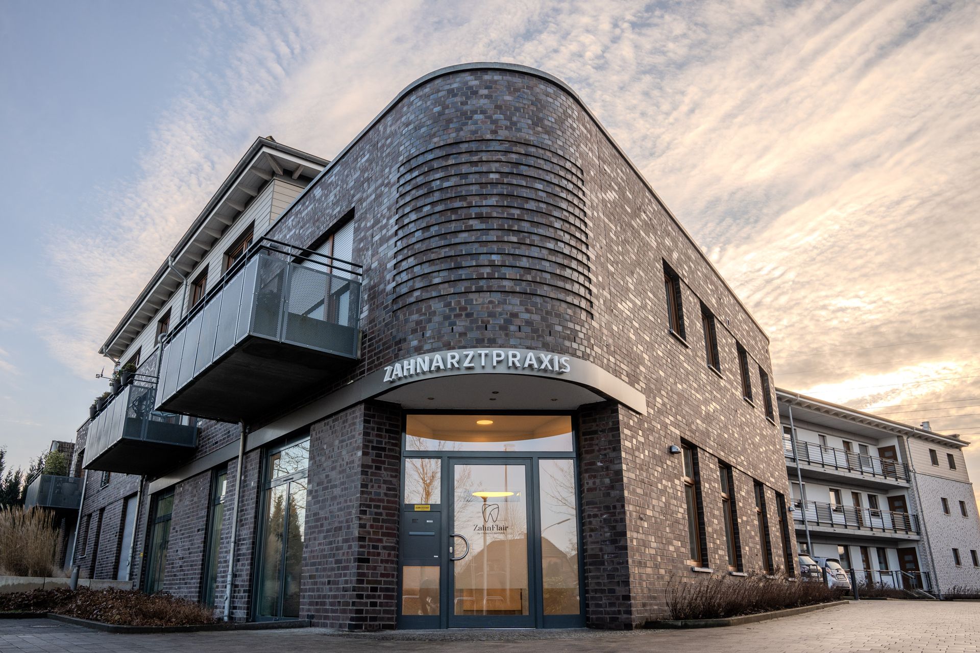 Ein großes Backsteingebäude mit einem Balkon und einer Tür.