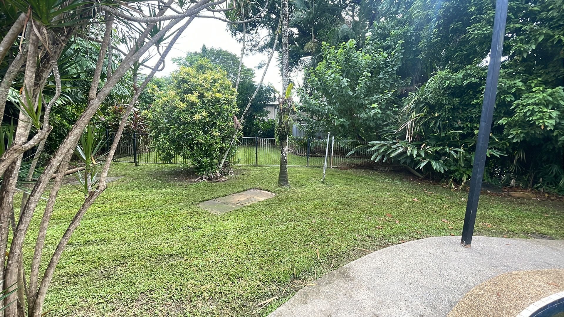 Lush Green Yard with Trees and Bushes, a Stone Path, and A Black Pole — Lads Lawns & Gardens in Bentley Park, QLD