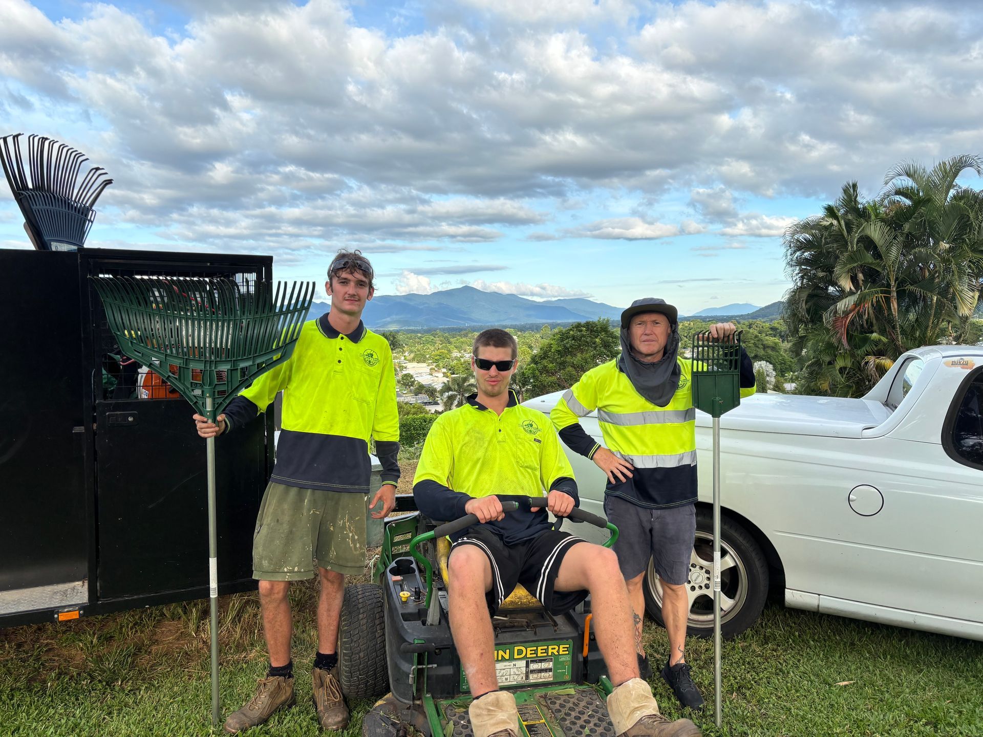 Three People in Work Clothes with Rakes and Mower, Posing Outside — Lads Lawns & Gardens in Bentley Park, QLD