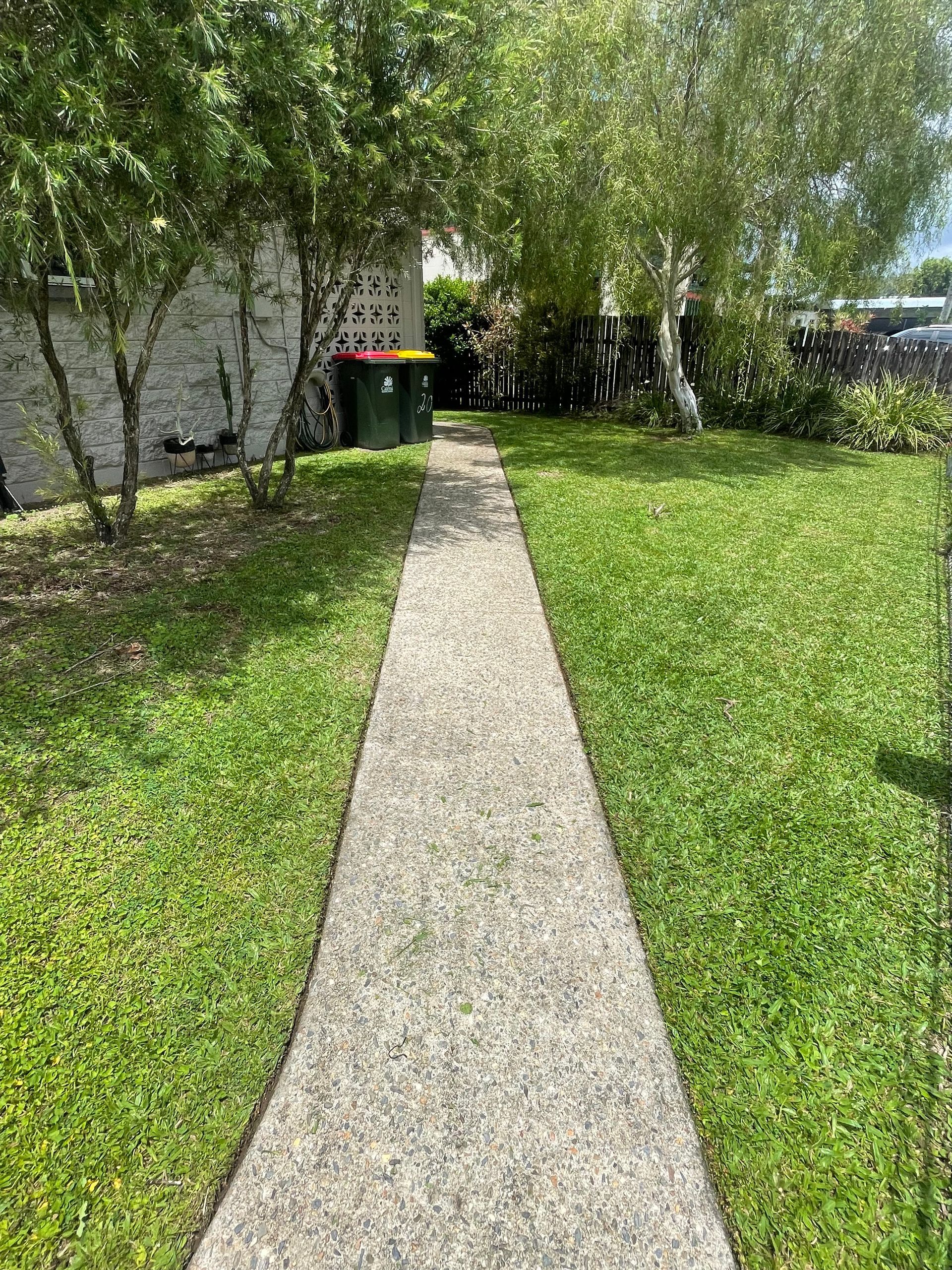 Concrete Path Through Green Lawn, Leading to Trees and A Trash Bin — Lads Lawns & Gardens in Bentley Park, QLD