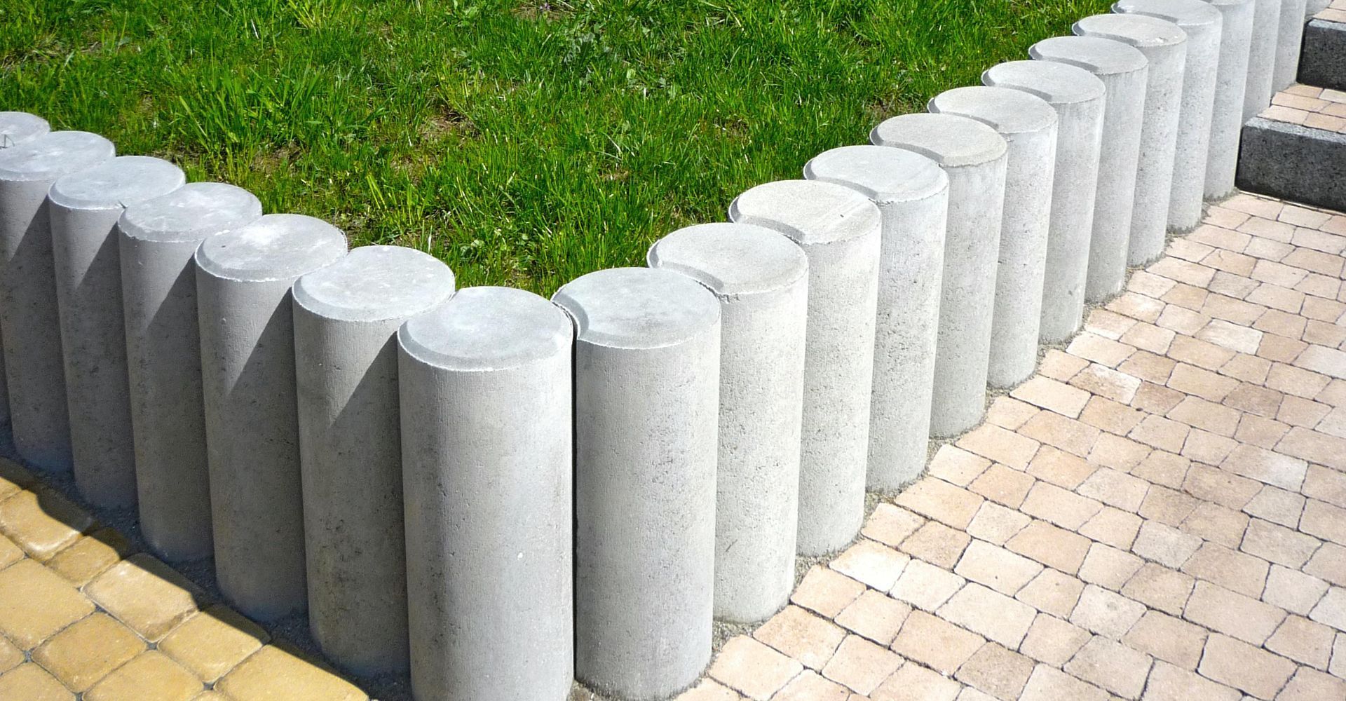 Concrete Pillars Form a Low Fence Around a Grass Area Next to A Brick Path — Lads Lawns & Gardens in Bentley Park, QLD