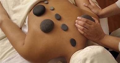 A woman is getting a hot stone massage at a spa.