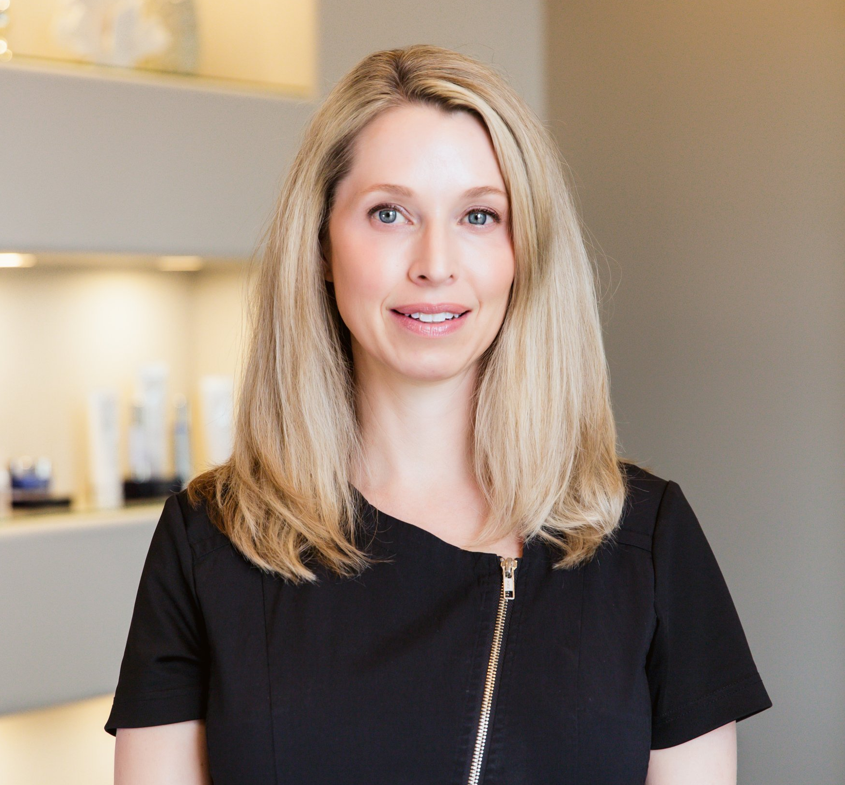 A woman in a black shirt is smiling for the camera