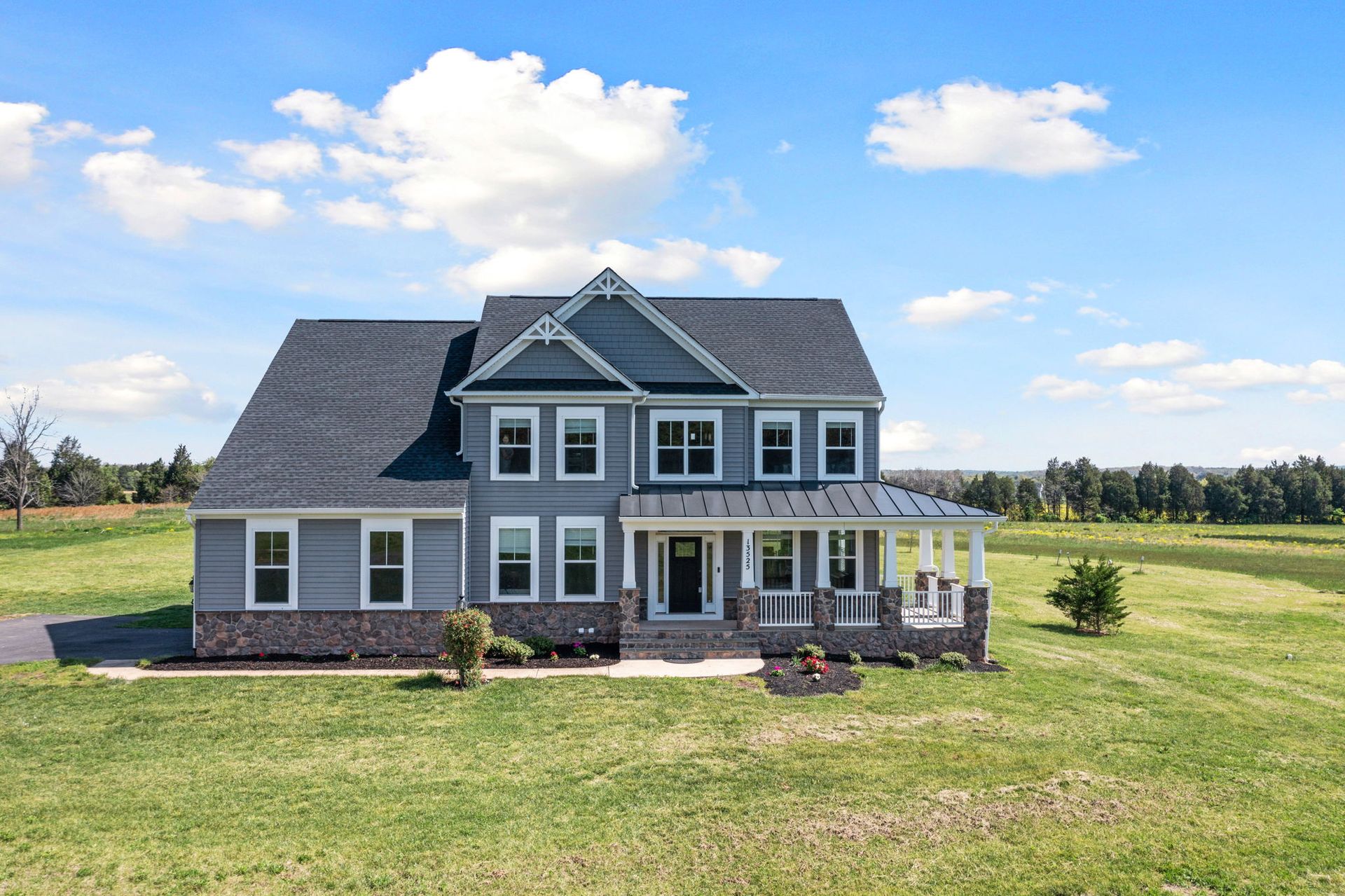 A large house is sitting on top of a lush green field.