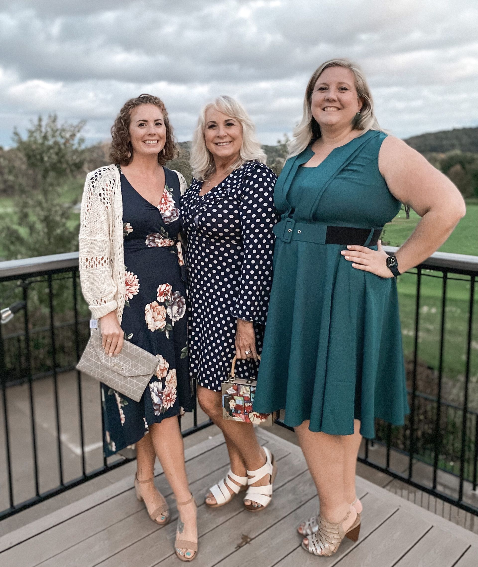 Three women are standing next to each other on a balcony.