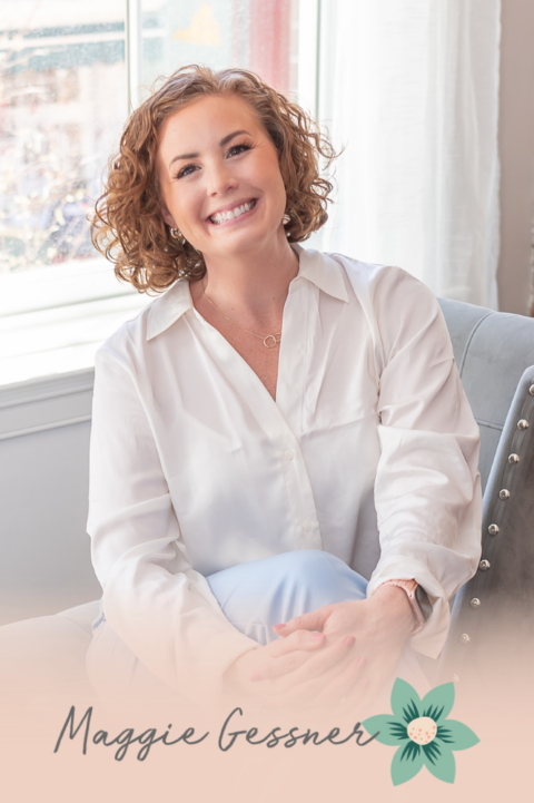 A woman is sitting in a chair in front of a window and smiling.