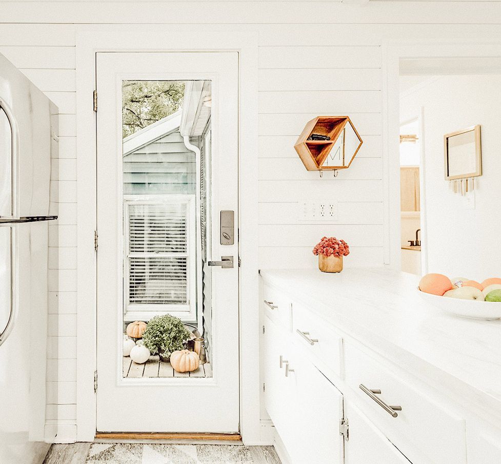 A kitchen with white cabinets , a washer and dryer , and a glass door. A kitchen with white cabinets , a washer and dryer , and a glass door.