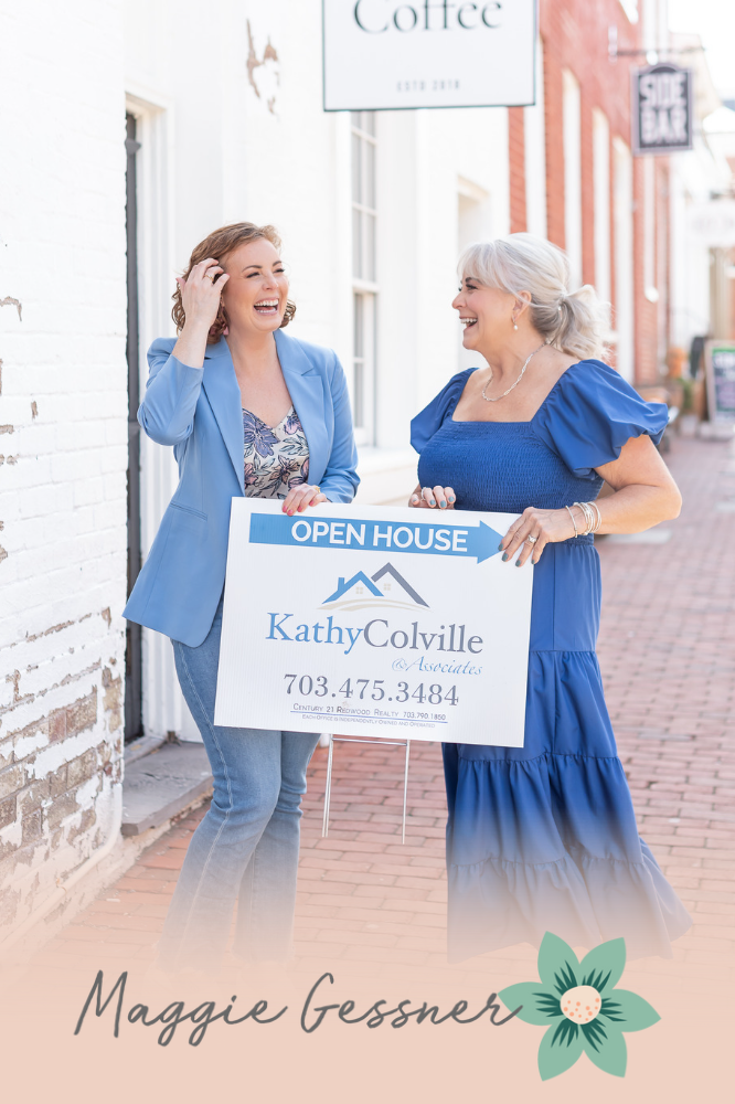 Two women are holding an open house sign in front of a building. Two women are holding an open house sign in front of a building.