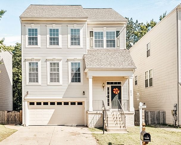 A white house with a large garage and a mailbox in front of it