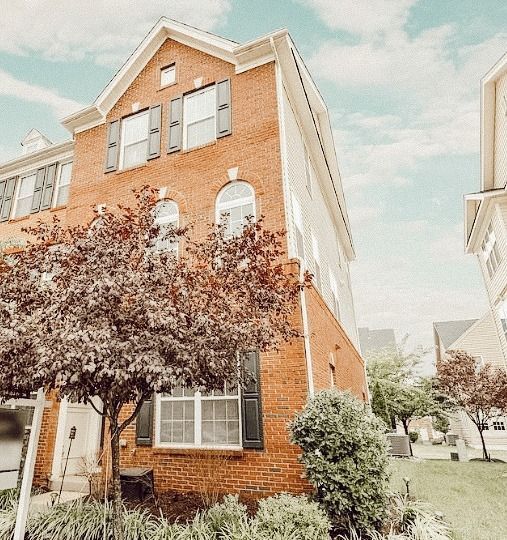 A large brick house with a lot of windows and trees in front of it.