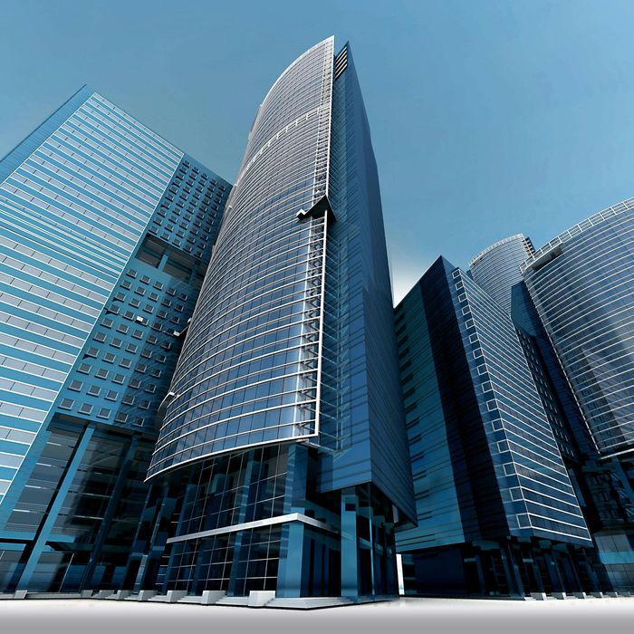 A group of tall, modern skyscrapers with blue glass facades reaches toward a clear sky from a low-angle perspective.