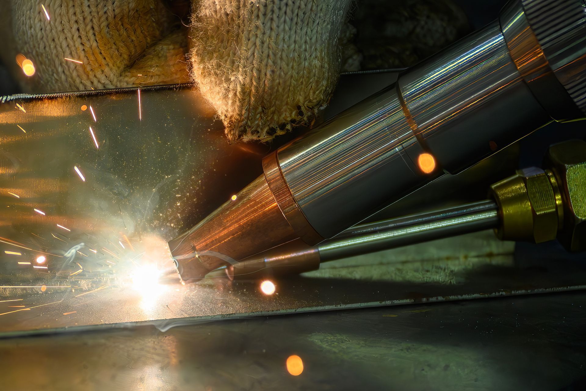 Industrial welding sparks beside metal pipes in a factory setting