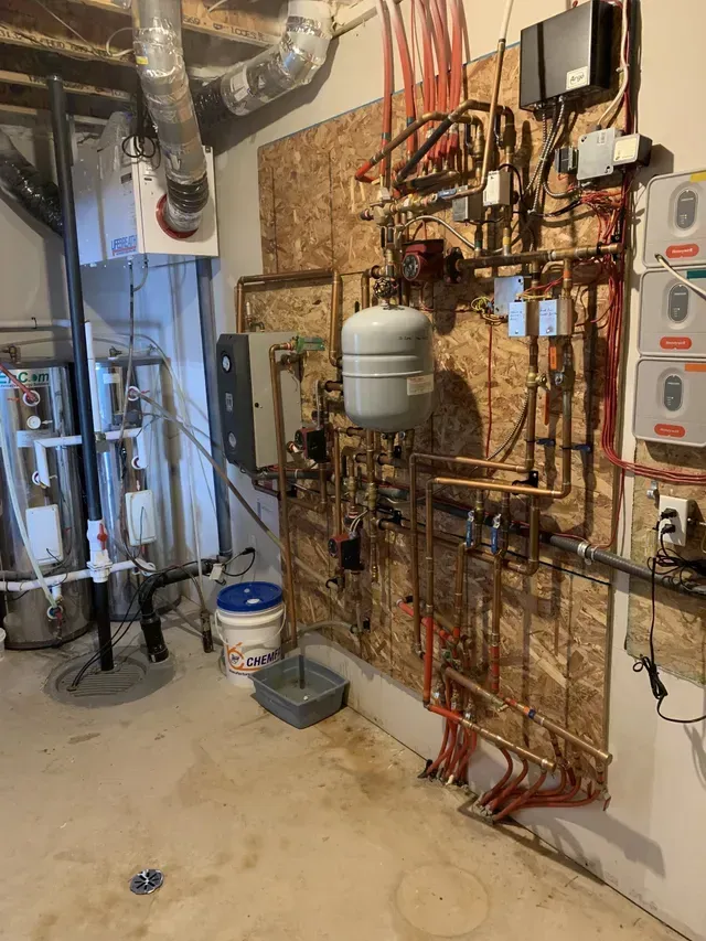 A room with a lot of pipes hanging on the wall.