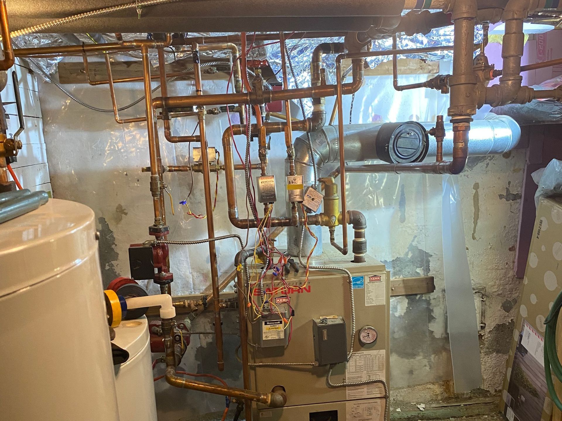 A room filled with lots of pipes and a boiler.
