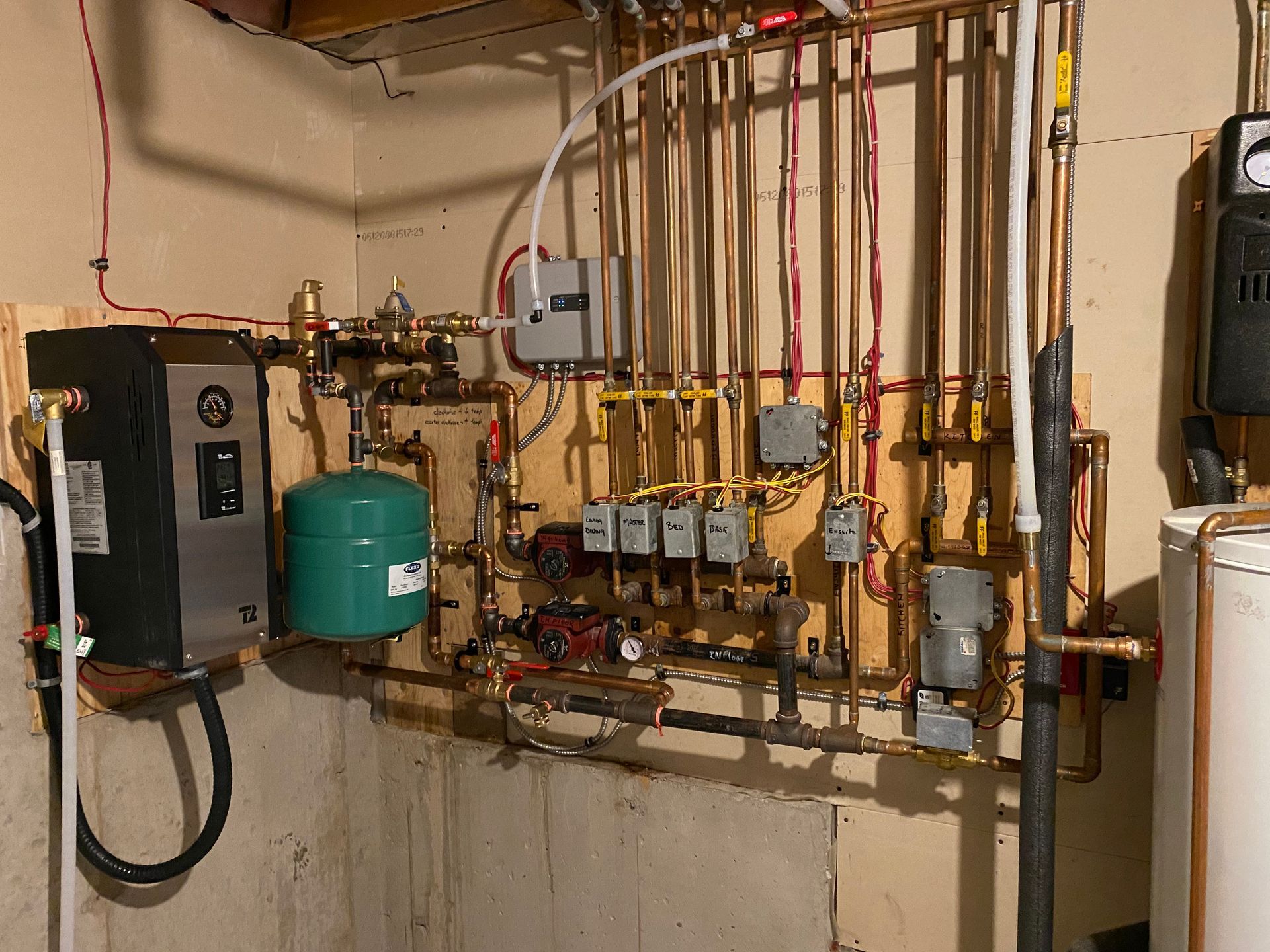 A room with a lot of pipes and a water heater.