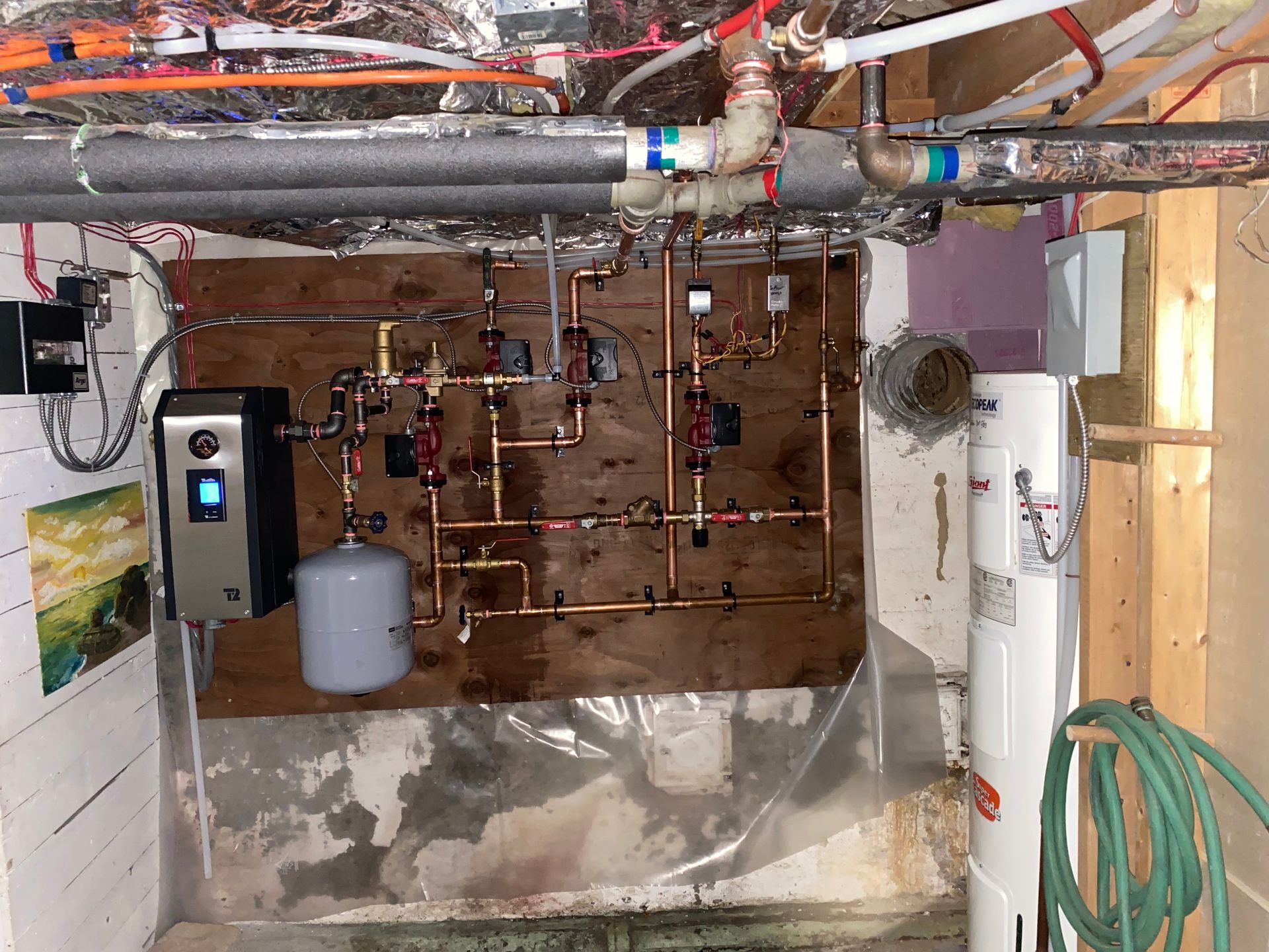 A room with a lot of pipes and a water heater