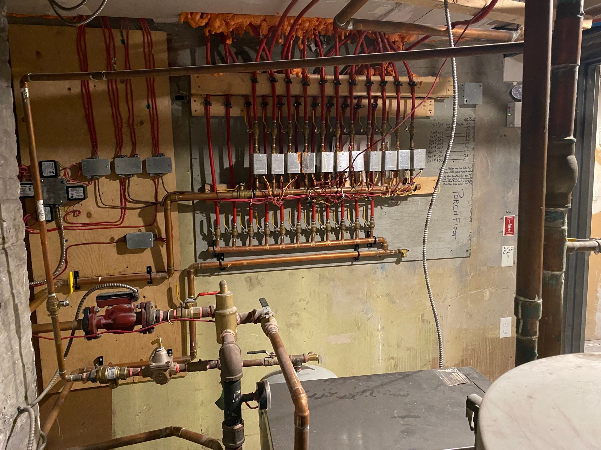 A room with a lot of pipes and wires on the wall.