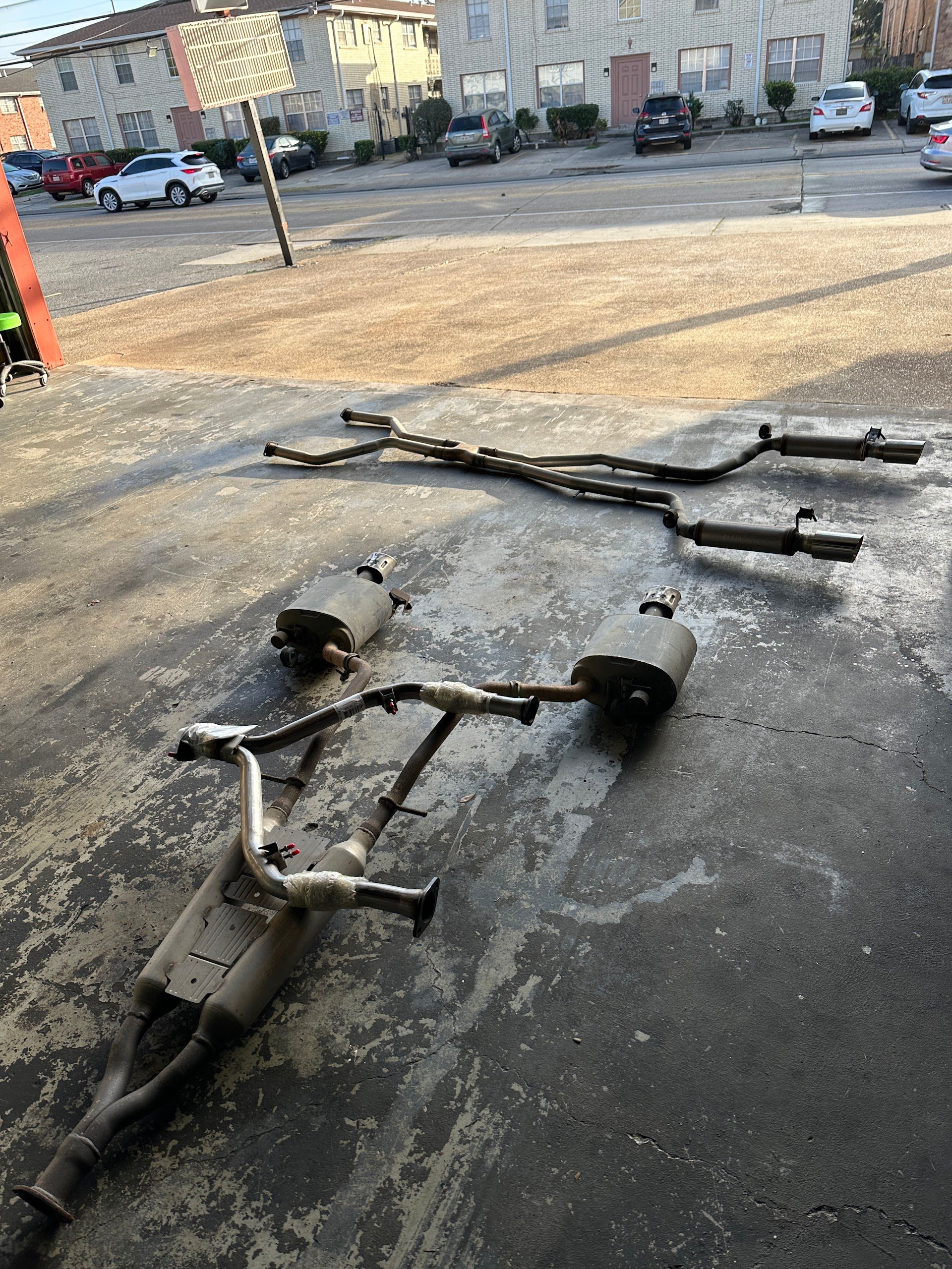 Exhaust System Components Laid on Asphalt | Mike's Auto Center