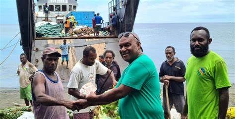 A group of men are shaking hands in front of a boat.