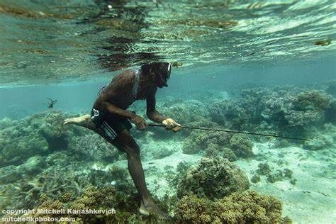 A man is fishing in the ocean with a fishing rod.