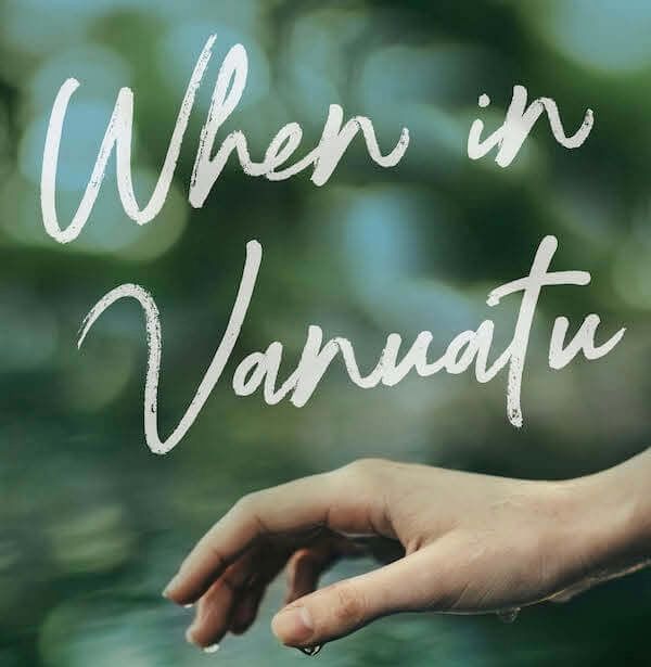 A hand is reaching out towards the words when in vanuatu