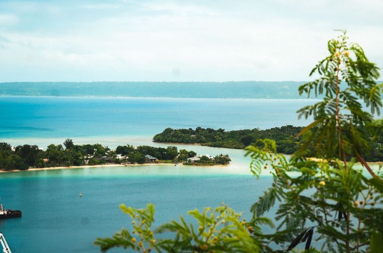 A view of a small island in the middle of a large body of water.