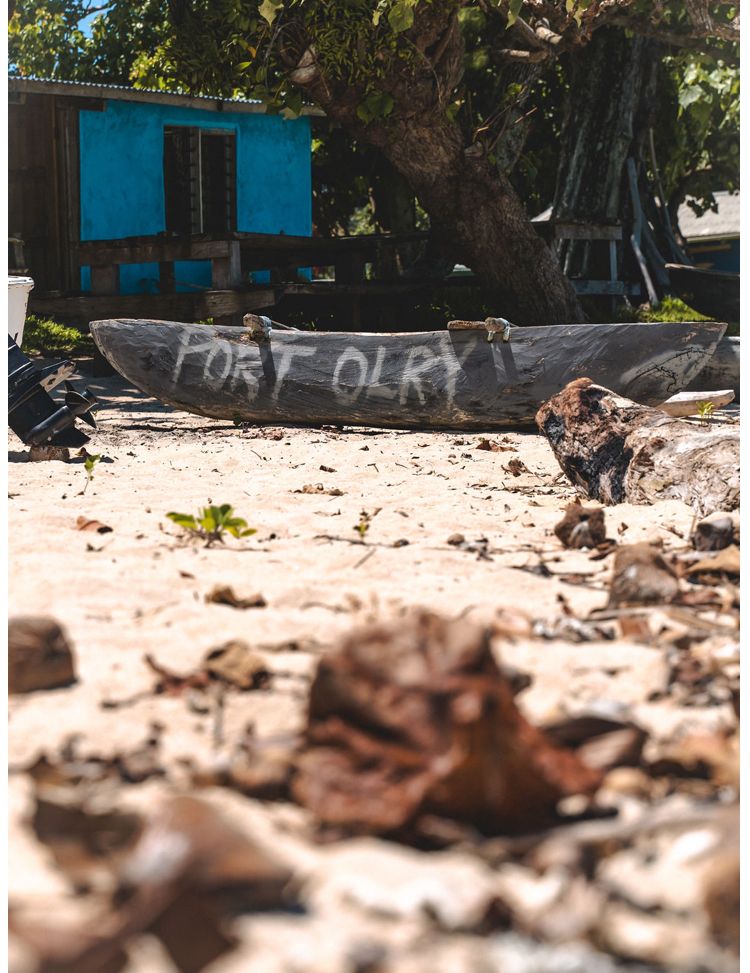 A boat is sitting on the beach with the word port written on it.