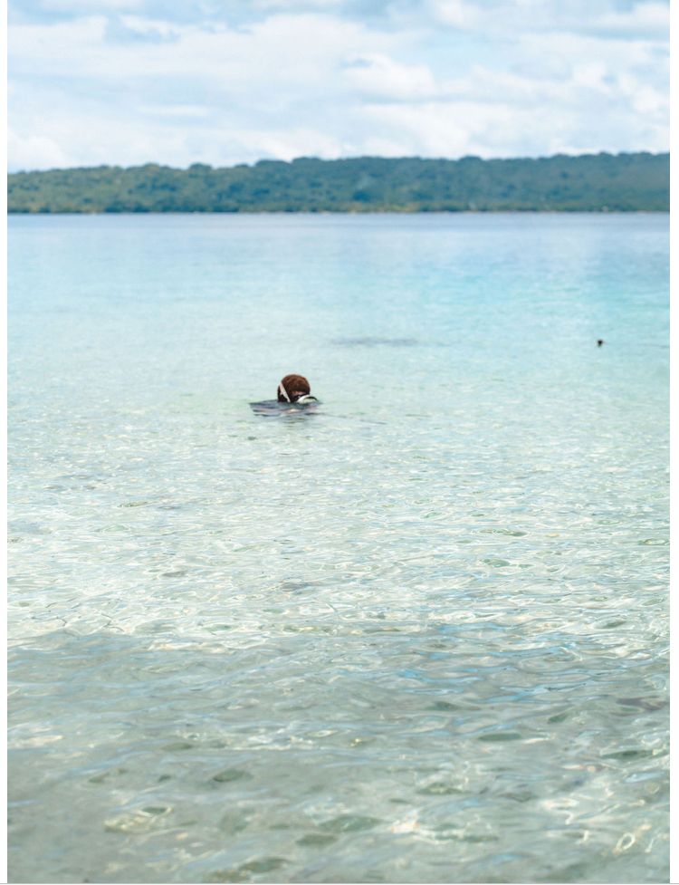 A person is swimming in a large body of water.