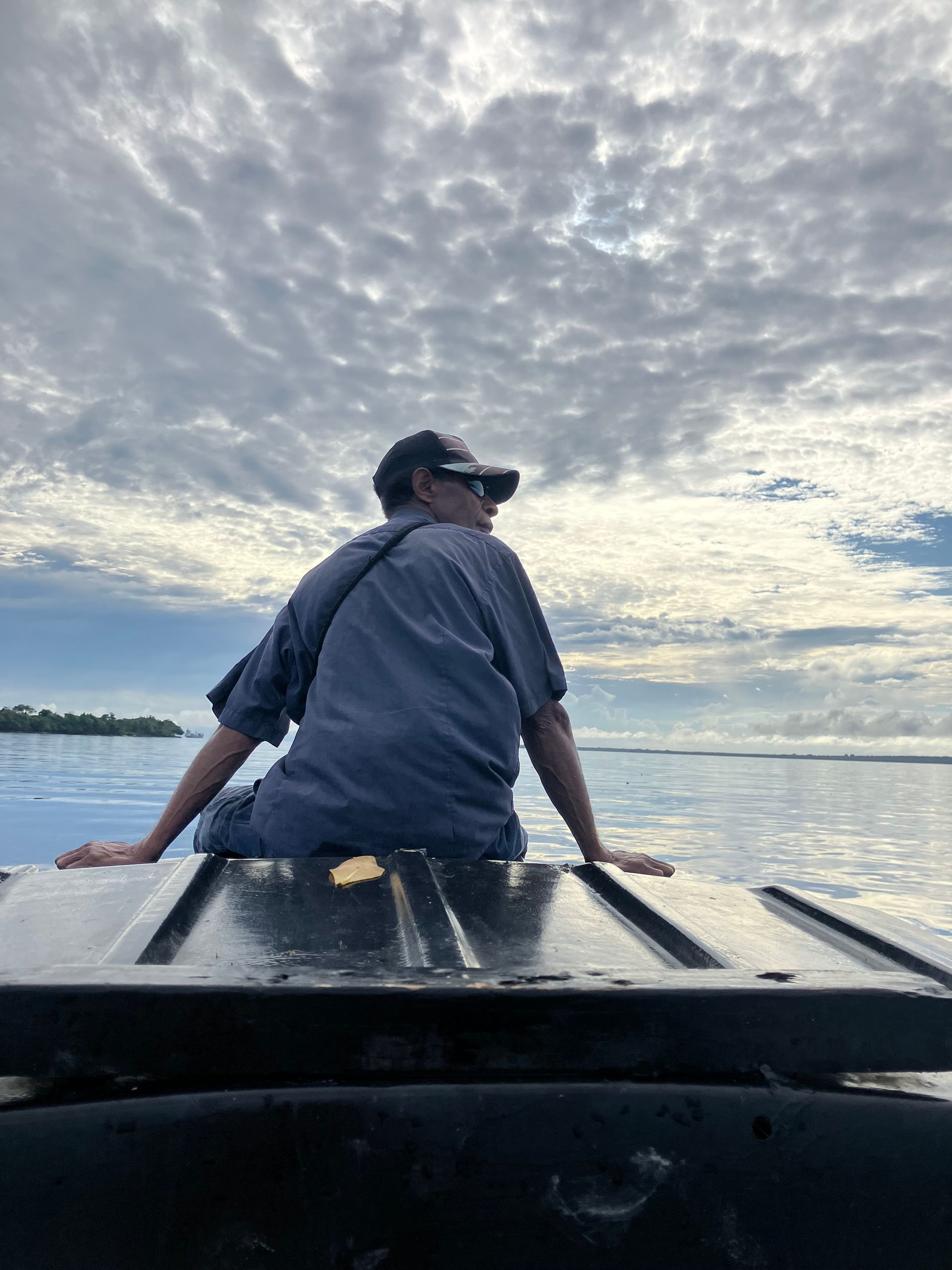 Rex on the boat with clouds and on Phoenix Plantations boat