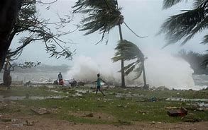 A person is walking on a beach during a hurricane.