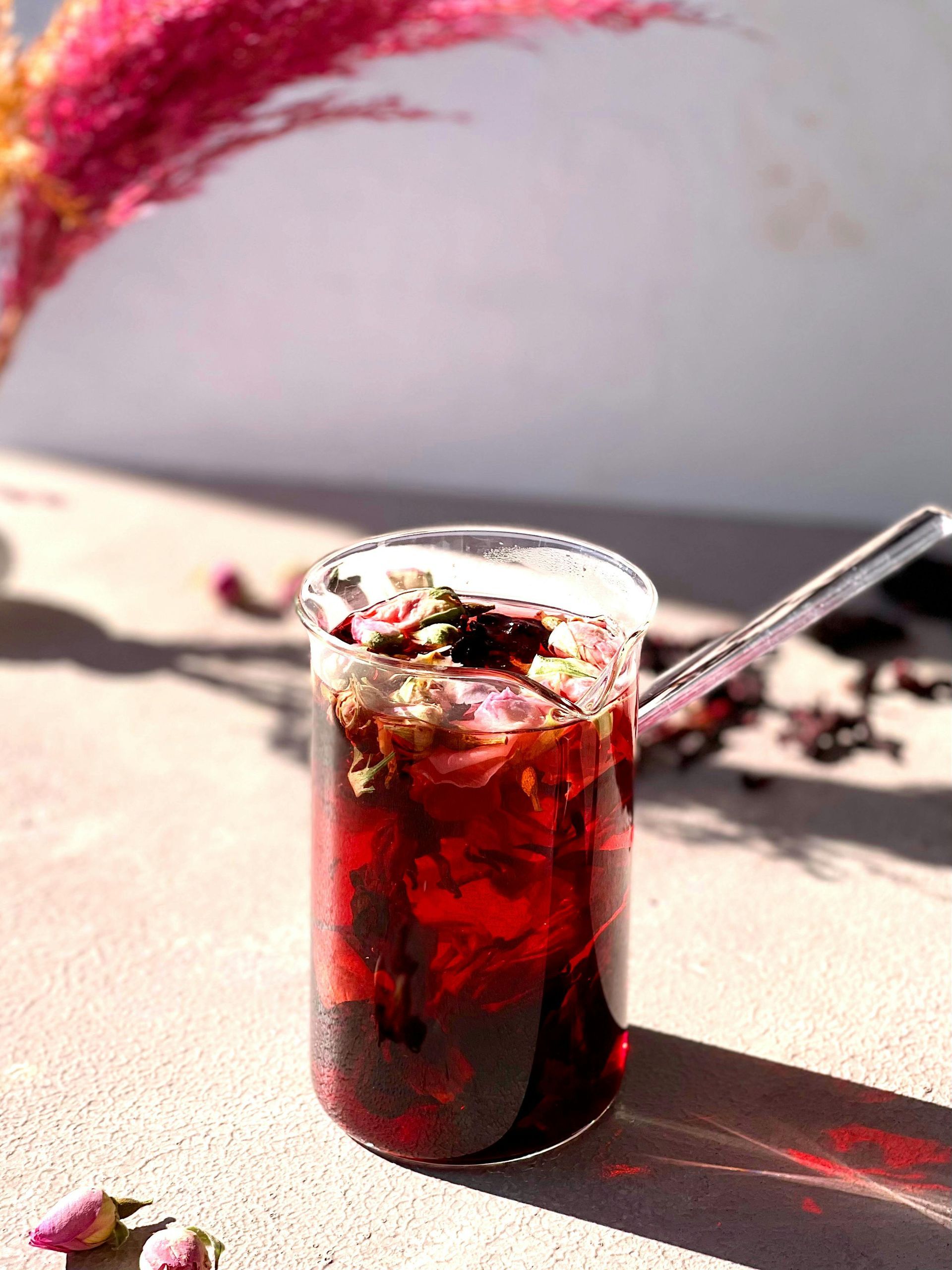 A glass of tea with a cinnamon stick , lemon slice and star anise.