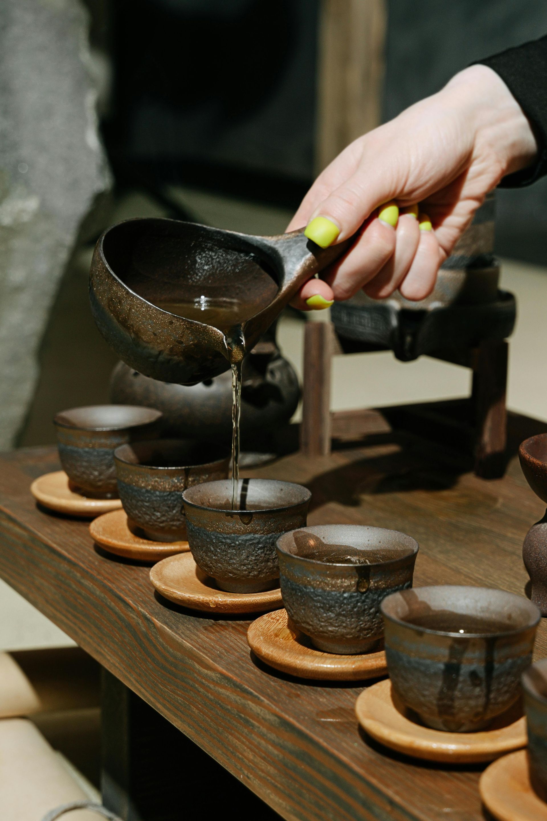 A teapot and cups are sitting on a wooden tray.